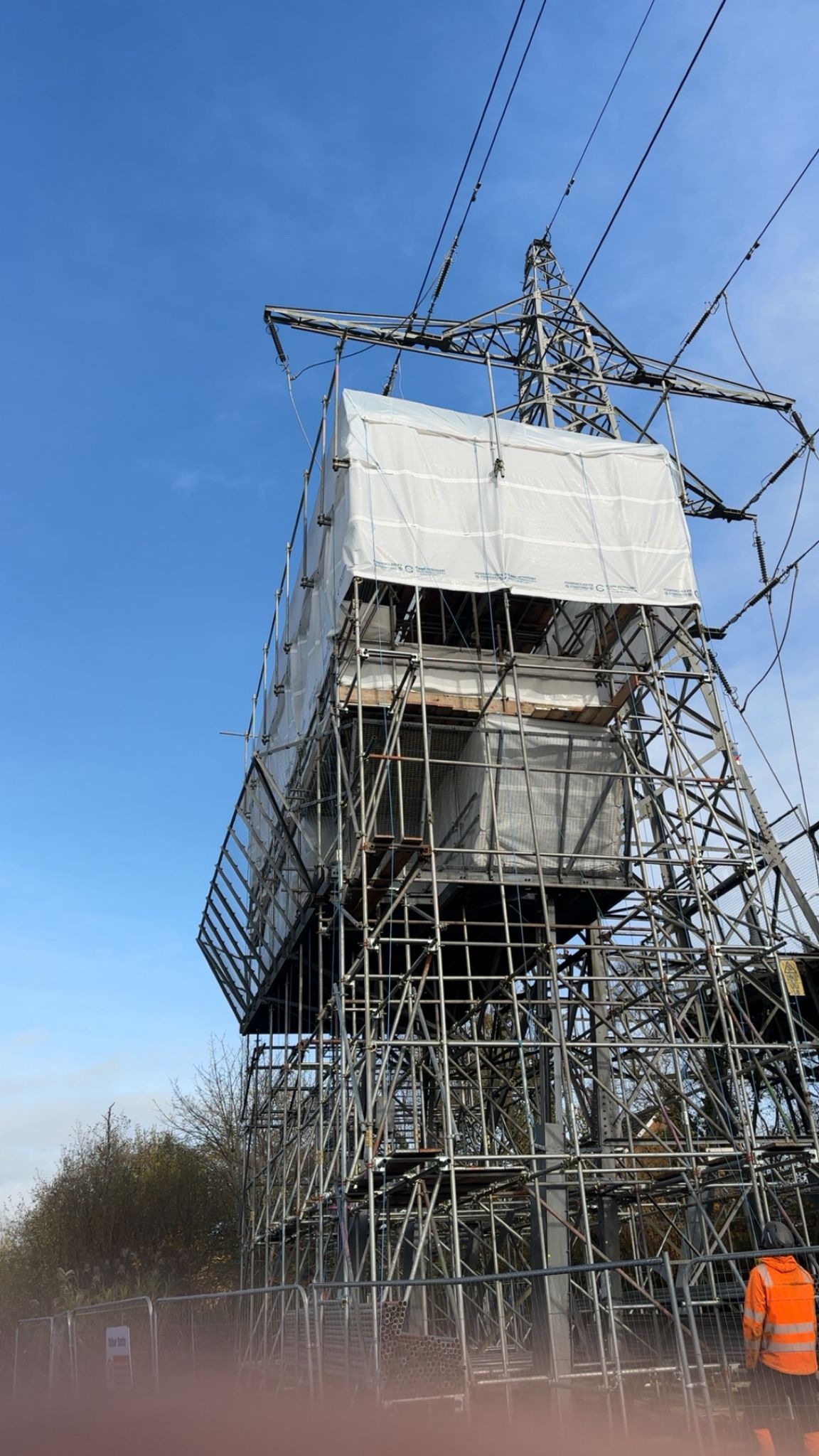 Specialist encapsulated scaffold to a steel pylon